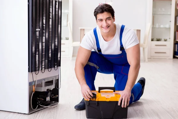 Repairman contractor repairing fridge in DIY concept