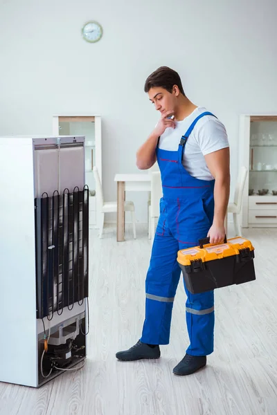 Repairman contractor repairing fridge in DIY concept