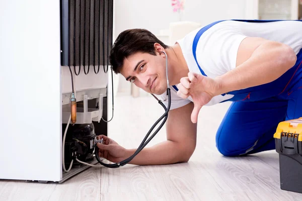 Repairman contractor repairing fridge in DIY concept