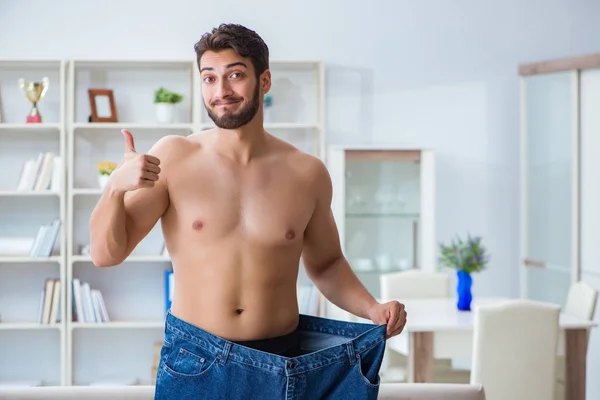 Hombre en pantalones de gran tamaño en concepto de pérdida de peso —  Fotos de Stock