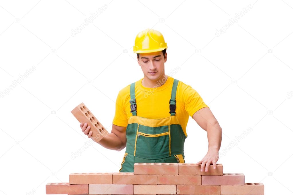 The handsome construction worker building brick wall