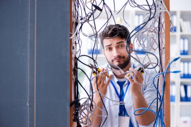 Elektrik teknisyeni tamir konseptinde kabloları çözmeye çalışıyor.