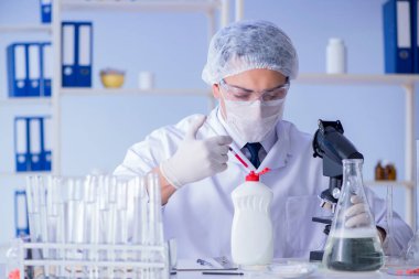 Laboratuvardaki adam yeni temizlik çözeltisi deterjanı test ediyor.