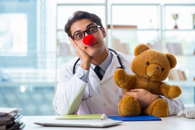 Hastane kliniğinde oyuncak taşıyan komik bir çocuk doktoru.