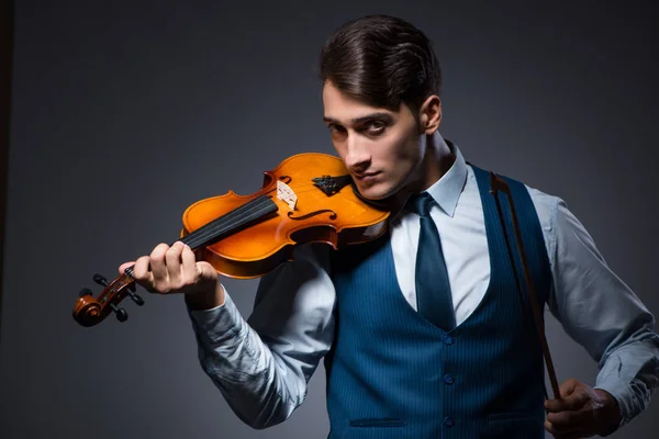 Young man playing violin in dark room — Stock Photo, Image