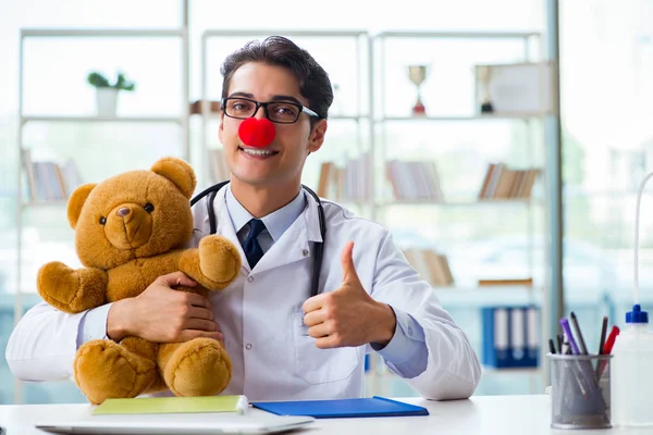 Hastane kliniğinde oyuncak taşıyan komik bir çocuk doktoru.