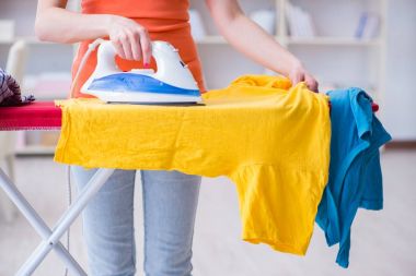 Kadın karısı evde ütü yapıyor.