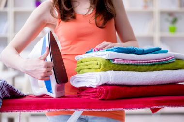 Kadın karısı evde ütü yapıyor.