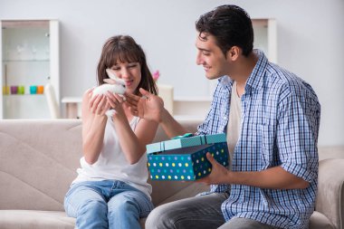 Genç bir kadın doğum günü hediyesi olarak evcil tavşan alıyor.