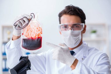 Hastane kliniğinde kan örnekleriyle çalışan bir doktor.