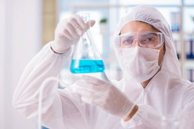 Laboratuvarda zehirli kimyasallarla çalışan bir kimyager.