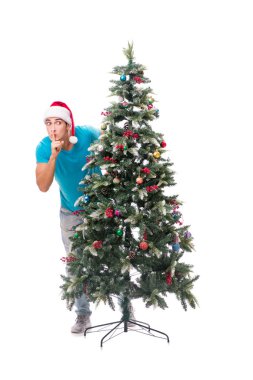 Genç adam beyaz üzerine izole edilmiş noel ağacını süslüyor.