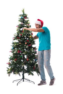 Genç adam beyaz üzerine izole edilmiş noel ağacını süslüyor.