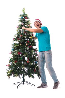 Genç adam beyaz üzerine izole edilmiş noel ağacını süslüyor.