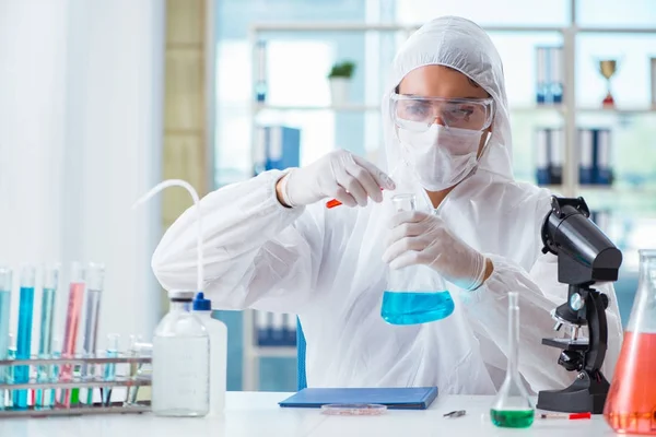 Químico que trabaja en el laboratorio con productos químicos peligrosos — Foto de Stock