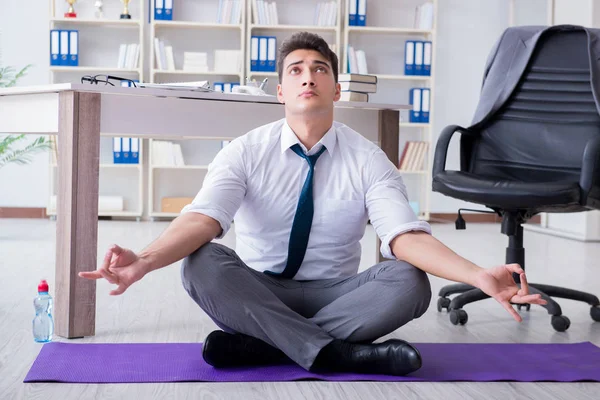 Man meditating in the office to cope with stress — Stock Photo, Image