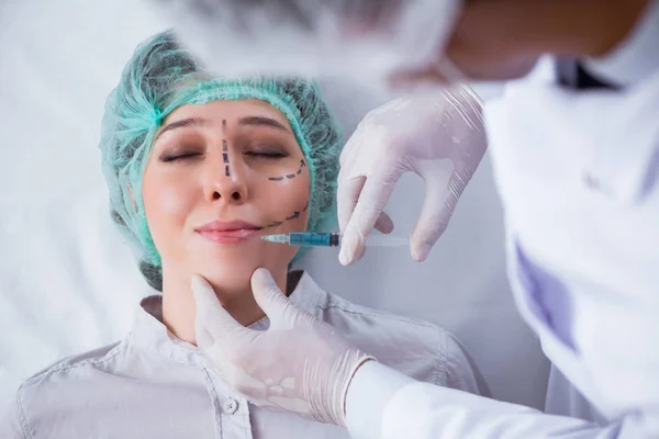 Plastic surgeon preparing for operation on woman face — Stock Photo, Image