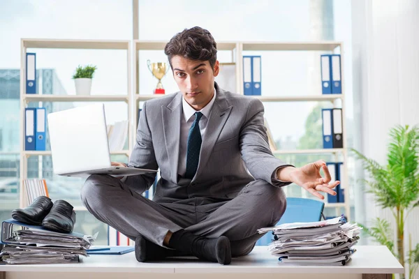 Бизнесмен, сидящий на столе в офисе — стоковое фото