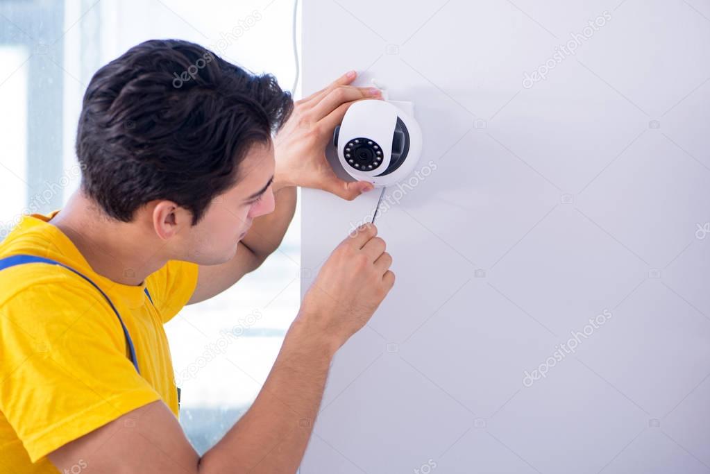 Contractor installing surveillance CCTV cameras in office