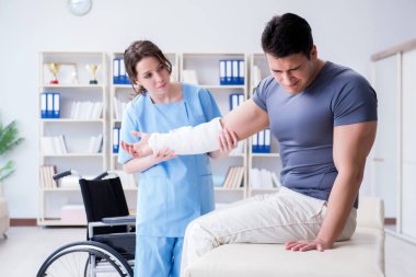 Hastanede yaralanma kontrolü sırasında doktor ve hasta.