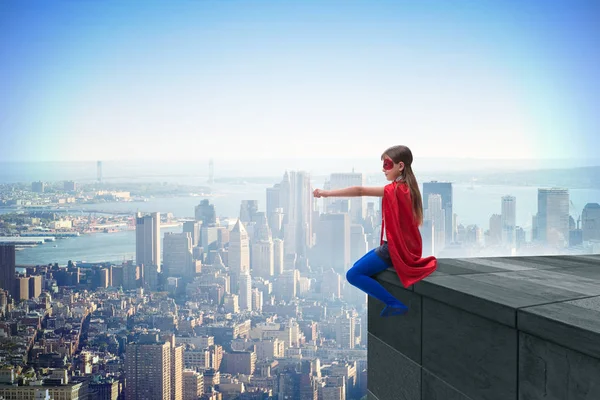 Menina em traje de super-herói com vista para a cidade — Fotografia de Stock