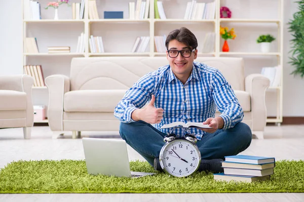 Genç yakışıklı adam evde yerde oturuyor.