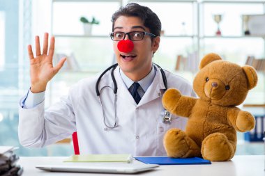 Hastane kliniğinde oyuncak taşıyan komik bir çocuk doktoru.