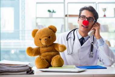 Hastane kliniğinde oyuncak taşıyan komik bir çocuk doktoru.