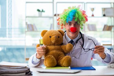 Hastane kliniğinde oyuncak taşıyan komik bir çocuk doktoru.