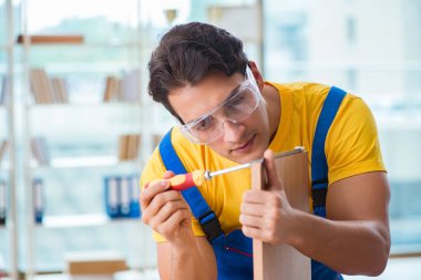 Mobilya marangozu atölyede çalışıyor.