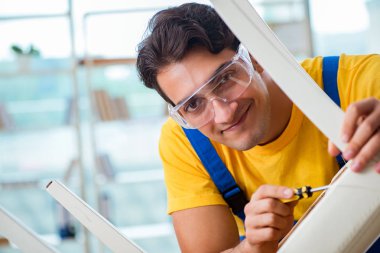 Mobilya tamircisi sandalyeyi tamir etmeye çalışıyor.