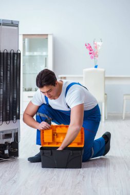 Tamirci müteahhit DIY konseptinde buzdolabını tamir ediyor.