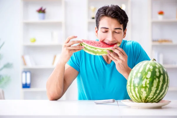 Ο άνθρωπος τρώει καρπούζι στο σπίτι — Φωτογραφία Αρχείου