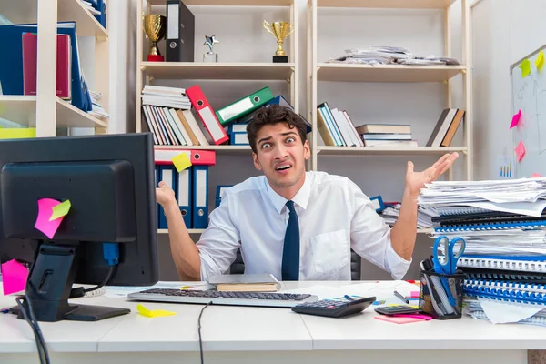 Uomo d'affari che lavora in ufficio con mucchi di libri e carte — Foto Stock