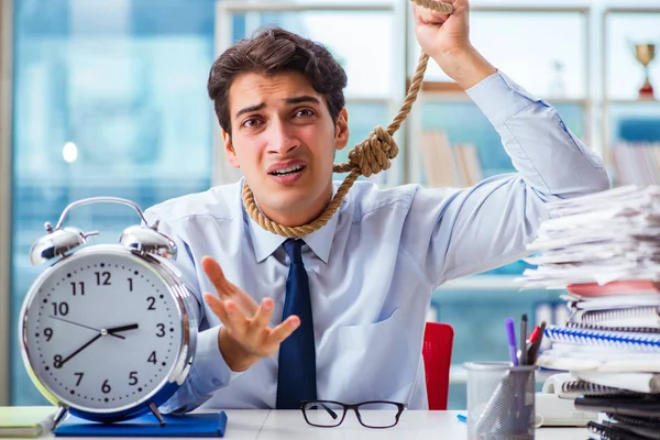 Unhappy businessman thinking of hanging himself in the office