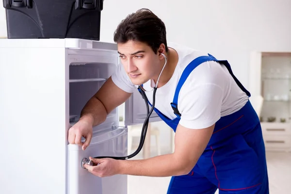 Reparador contratante reparação de geladeira no conceito DIY — Fotografia de Stock