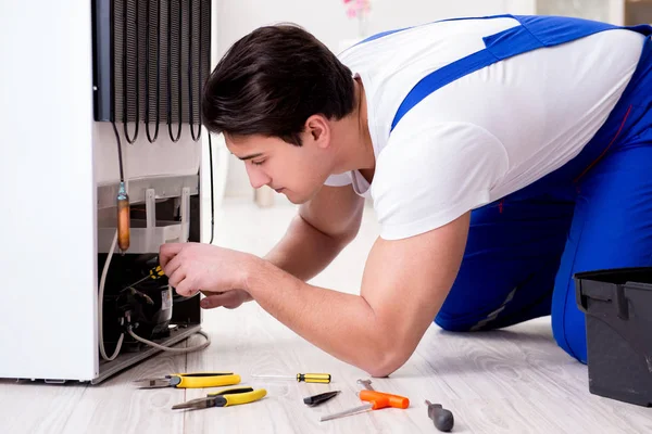 Repairman contractor repairing fridge in DIY concept