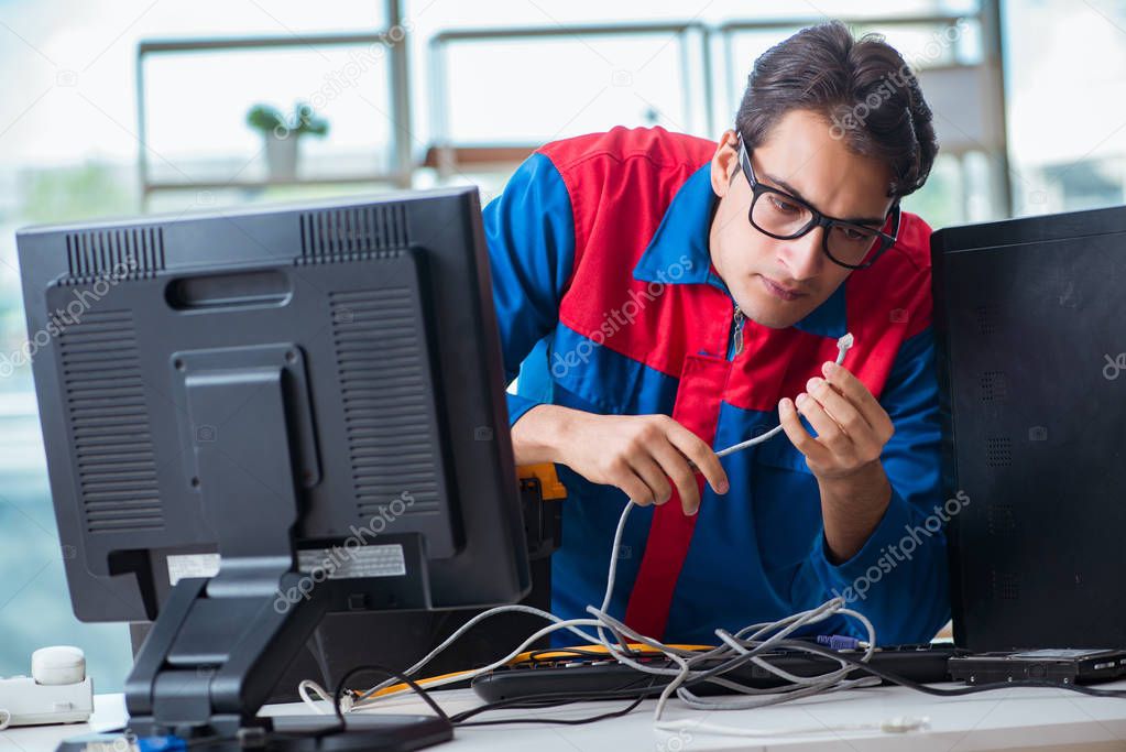 Computer repairman working on repairing computer in IT workshop