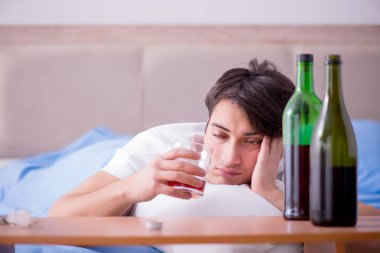 Yatakta içen alkolik adam depresyona giriyor.