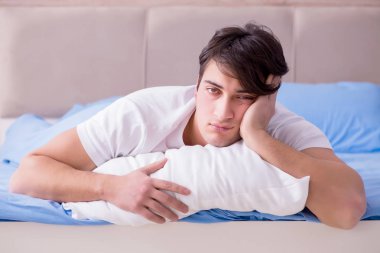 Uykusuzluk çeken bir adam yatakta yatıyor.