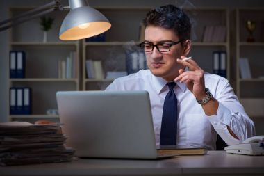 Stres altındaki iş adamı ofiste sigara içiyor