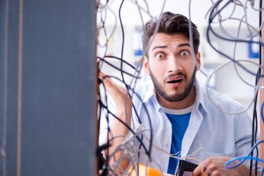 Elektrik teknisyeni tamir konseptinde kabloları çözmeye çalışıyor.