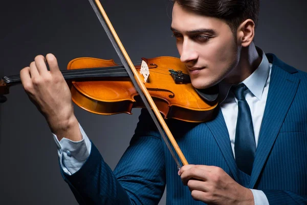 Jeune homme jouant du violon dans la chambre noire — Photo