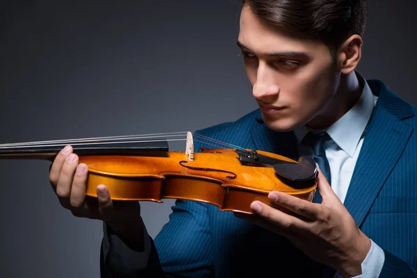 Young man playing violin in dark room — Stock Photo, Image