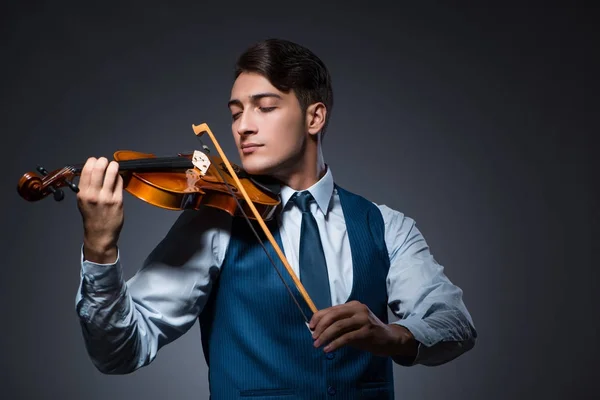 Jovem tocando violino no quarto escuro — Fotografia de Stock