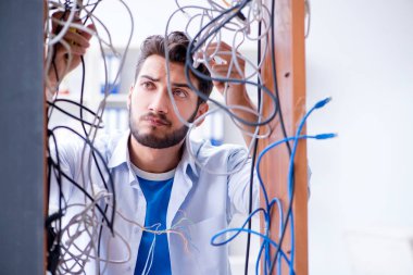 Elektrik teknisyeni tamir konseptinde kabloları çözmeye çalışıyor.