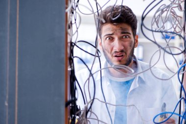 Elektrik teknisyeni tamir konseptinde kabloları çözmeye çalışıyor.