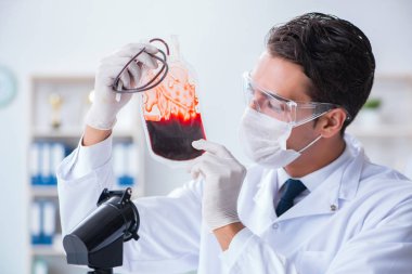 Hastane kliniğinde kan örnekleriyle çalışan bir doktor.