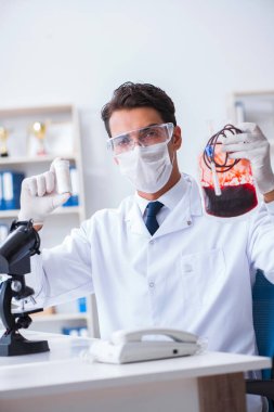 Hastane kliniğinde kan örnekleriyle çalışan bir doktor.
