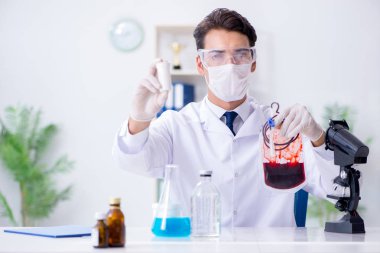 Hastane kliniğinde kan örnekleriyle çalışan bir doktor.